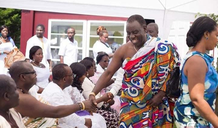 Two Akan elders are shaking hands.