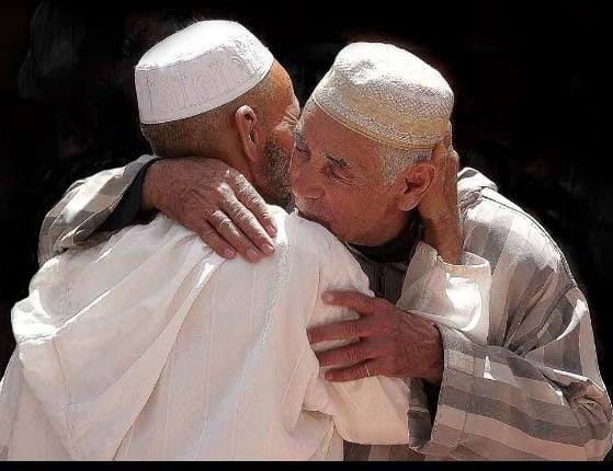 Two elders in North Africa greet each other with a kiss on the cheek