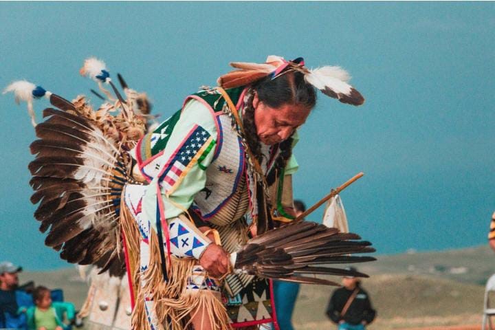 A Lakota older woman bowing as a way of greeting.