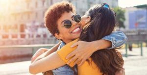 Two young ladies share a Greek hug.