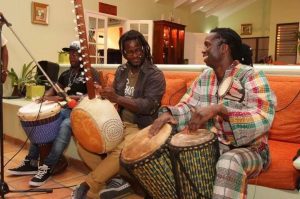 Young West African men playing the djembe and kora.