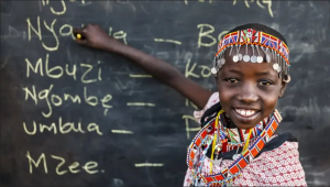 A black kid writing on a black board