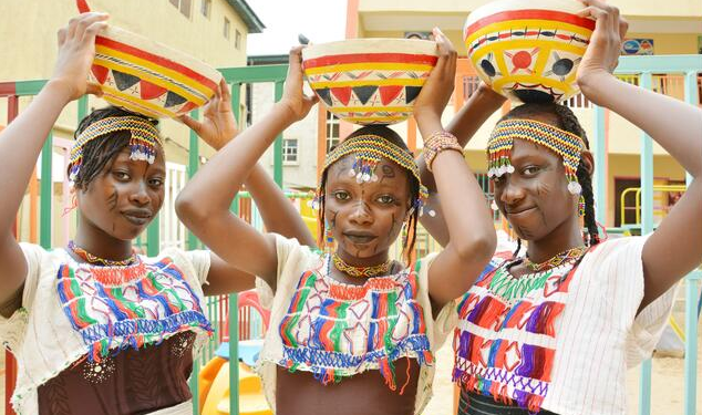 Three black beautiful ladies in ornaments carrying little basket